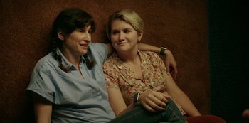 Movie still from “Sword of Trust” (2019), directed by Lynn Shelton – A couple of women sitting next to each other on top of a couch; Close Up shot, High angle