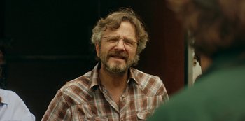 Movie still from “Sword of Trust” (2019), directed by Lynn Shelton – A person wearing glasses and a plaid shirt; Close Up shot, Over the shoulder angle
