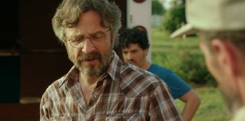 Movie still from “Sword of Trust” (2019), directed by Lynn Shelton – A man in a plaid shirt and a man in a blue and white checkered shirt; Close Up shot, Over the shoulder angle