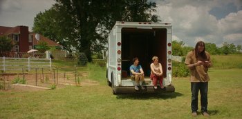 Movie still from “Sword of Trust” (2019), directed by Lynn Shelton – Two people sitting in the back of a white truck; Wide shot, Low angle