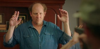 Movie still from “Sword of Trust” (2019), directed by Lynn Shelton – A man with a beard is holding his hand up in the air; Close Up shot, Over the shoulder angle