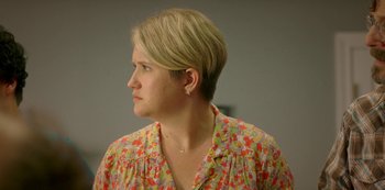 Movie still from “Sword of Trust” (2019), directed by Lynn Shelton – A woman with blonde hair wearing a floral shirt; Close Up shot, Over the shoulder angle