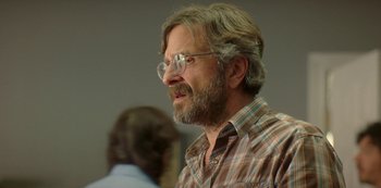 Movie still from “Sword of Trust” (2019), directed by Lynn Shelton – An older man with a beard wearing glasses; Close Up shot, Over the shoulder angle