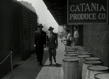 Movie still from “T-Men” (1947), directed by Anthony Mann – A black and white photo of two men walking down a street; Wide shot, Low angle