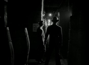 Movie still from “T-Men” (1947), directed by Anthony Mann – Two men are standing in a dark alley; Wide shot, Over the shoulder angle