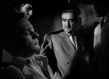 Movie still from “T-Men” (1947), directed by Anthony Mann – A black - and - white photo of three men in suits; Medium shot, Low angle