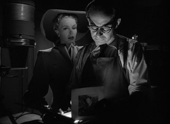 Movie still from “T-Men” (1947), directed by Anthony Mann – A man and a woman looking at a picture; Medium shot, Low angle