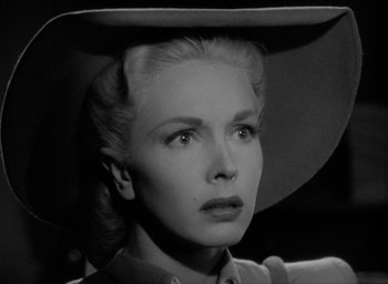 Movie still from “T-Men” (1947), directed by Anthony Mann – A black and white photo of a woman in a cowboy hat; Close Up shot, Low angle