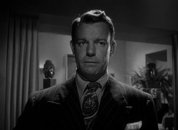 Movie still from “T-Men” (1947), directed by Anthony Mann – A black and white photo of a man in a suit and tie; Close Up shot, Low angle