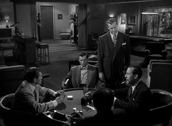 Movie still from “T-Men” (1947), directed by Anthony Mann – A black and white photo of men in suits playing poker; Wide shot, High angle