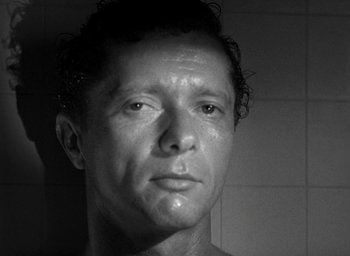 Movie still from “T-Men” (1947), directed by Anthony Mann – Black and white photograph of a man in the shower; Close Up shot, Low angle