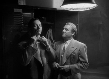 Movie still from “T-Men” (1947), directed by Anthony Mann – Two men in suits and ties looking at each other; Medium shot, Low angle