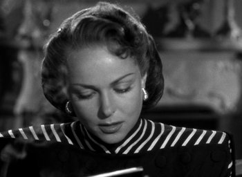 Movie still from “T-Men” (1947), directed by Anthony Mann – An old photo of a woman looking down at a piece of paper; Close Up shot, Over the shoulder angle