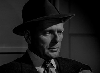Movie still from “T-Men” (1947), directed by Anthony Mann – A man wearing a suit and a hat; Close Up shot, Low angle