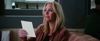 Movie still from “Table 19” (2017), directed by Jeffrey Blitz – A woman sitting in front of a window looking at a piece of paper; Close Up shot, Over the shoulder angle