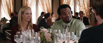 Movie still from “Table 19” (2017), directed by Jeffrey Blitz – A man and a woman sitting at a table with wine glasses; Medium shot, Over the shoulder angle