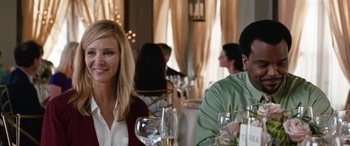 Movie still from “Table 19” (2017), directed by Jeffrey Blitz – A woman sitting at a table with a man in a green shirt; Close Up shot, Over the shoulder angle