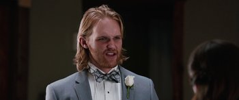 Movie still from “Table 19” (2017), directed by Jeffrey Blitz – A person wearing a suit and bow tie; Close Up shot, Low angle