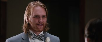 Movie still from “Table 19” (2017), directed by Jeffrey Blitz – A person wearing a suit and bow tie; Close Up shot, Over the shoulder angle