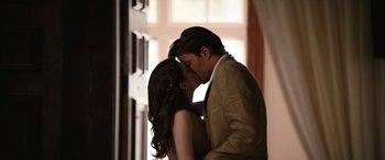 Movie still from “Table 19” (2017), directed by Jeffrey Blitz – A man and a woman kissing in front of a window; Medium shot, Low angle