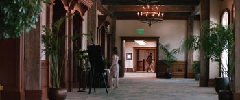 Movie still from “Table 19” (2017), directed by Jeffrey Blitz – A woman standing in front of an easel in a room; Wide shot, Over the shoulder angle