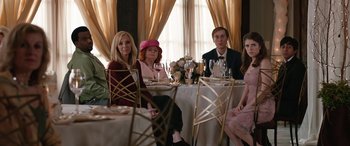 Movie still from “Table 19” (2017), directed by Jeffrey Blitz – A group of people sitting at a table with wine glasses; Medium shot, Over the shoulder angle