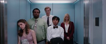 Movie still from “Table 19” (2017), directed by Jeffrey Blitz – A group of people standing next to each other in an elevator; Medium shot, Low angle