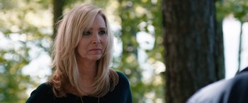 Movie still from “Table 19” (2017), directed by Jeffrey Blitz – A woman with blonde hair is standing in front of a tree; Close Up shot, Over the shoulder angle