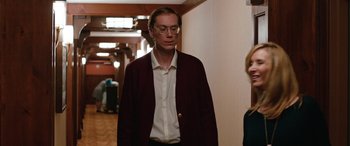 Movie still from “Table 19” (2017), directed by Jeffrey Blitz – A man wearing glasses and a red jacket; Medium shot, Over the shoulder angle