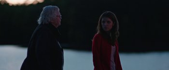 Movie still from “Table 19” (2017), directed by Jeffrey Blitz – A man and a woman standing next to each other in the dark; Medium shot, Over the shoulder angle