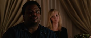 Movie still from “Table 19” (2017), directed by Jeffrey Blitz – A man and a woman standing next to each other; Close Up shot, Over the shoulder angle