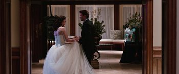 Movie still from “Table 19” (2017), directed by Jeffrey Blitz – A man and a woman in wedding attire holding hands; Wide shot, Over the shoulder angle