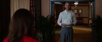 Movie still from “Table 19” (2017), directed by Jeffrey Blitz – A man standing in front of a mirror in a room; Medium shot, Over the shoulder angle