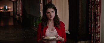 Movie still from “Table 19” (2017), directed by Jeffrey Blitz – A woman holding a plate with a piece of cake on top of it; Medium shot, Over the shoulder angle