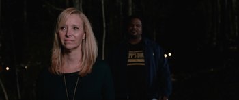 Movie still from “Table 19” (2017), directed by Jeffrey Blitz – A woman standing next to a man in front of trees; Medium shot, Over the shoulder angle
