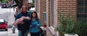 Movie still from “Table 19” (2017), directed by Jeffrey Blitz – A woman standing next to a brick building; Medium shot, Over the shoulder angle