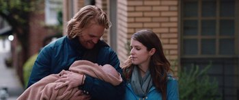 Movie still from “Table 19” (2017), directed by Jeffrey Blitz – A man and a woman holding a baby in her arms; Medium shot, Over the shoulder angle