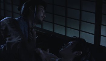 Movie still from “Taboo” (1999), directed by Nagisa Ôshima – Two young men are looking at each other in the dark; Medium shot, Over the shoulder angle