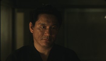 Movie still from “Taboo” (1999), directed by Nagisa Ôshima – A person wearing a black shirt; Close Up shot, Over the shoulder angle