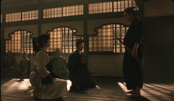 Movie still from “Taboo” (1999), directed by Nagisa Ôshima – A group of people sitting on the ground in a room; Wide shot, Low angle