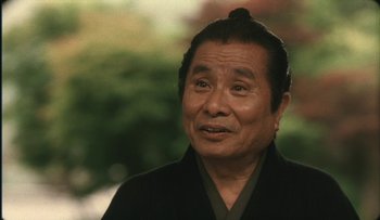 Movie still from “Taboo” (1999), directed by Nagisa Ôshima – An older asian man wearing a black jacket; Close Up shot, Low angle