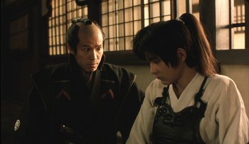 Movie still from “Taboo” (1999), directed by Nagisa Ôshima – Two men in traditional garb talking to each other; Close Up shot, Over the shoulder angle