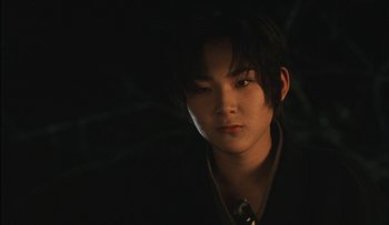 Movie still from “Taboo” (1999), directed by Nagisa Ôshima – A young man in a suit and a tie in the dark; Close Up shot, Low angle