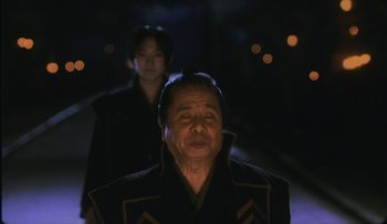 Movie still from “Taboo” (1999), directed by Nagisa Ôshima – An older man and a young woman in the dark; Close Up shot, Over the shoulder angle