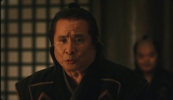 Movie still from “Taboo” (1999), directed by Nagisa Ôshima – An older man in a black jacket looking at the camera; Close Up shot, Low angle