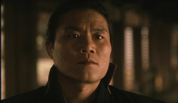 Movie still from “Taboo” (1999), directed by Nagisa Ôshima – A person wearing a black shirt; Close Up shot, Low angle