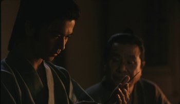 Movie still from “Taboo” (1999), directed by Nagisa Ôshima – A man and a woman looking at a cell phone; Close Up shot, Over the shoulder angle