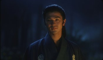 Movie still from “Taboo” (1999), directed by Nagisa Ôshima – A man in a black robe standing in the dark; Close Up shot, Low angle