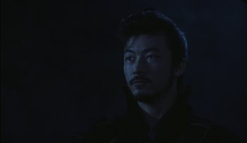 Movie still from “Taboo” (1999), directed by Nagisa Ôshima – A person wearing a black jacket; Close Up shot, Low angle
