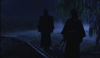 Movie still from “Taboo” (1999), directed by Nagisa Ôshima – Two people walking down a path in the dark; Wide shot, Low angle